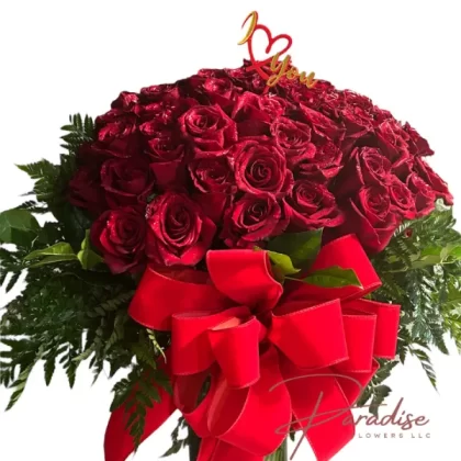 Amour Elegance Arrangement featuring 100 red roses with lush greenery in an elegant vase.