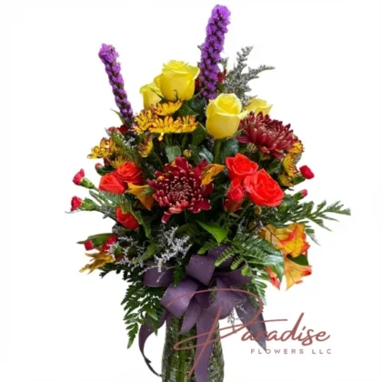 Autumn Whisper Florals featuring yellow roses, red chrysanthemums, orange mini carnations, orange spray roses, yellow daisies, liatris, limonium, and lush greenery.