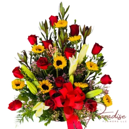 Celebration of Love bouquet featuring red roses, bright sunflowers, lilies, snapdragons, limonium, and lush greenery.