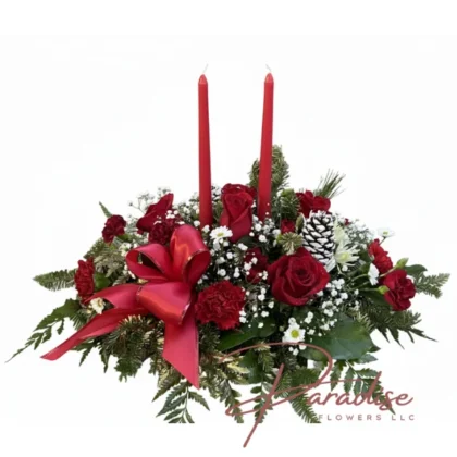 Christmas centerpiece with two red taper candles, red roses, white mums, frosted pinecones, and a red satin bow.