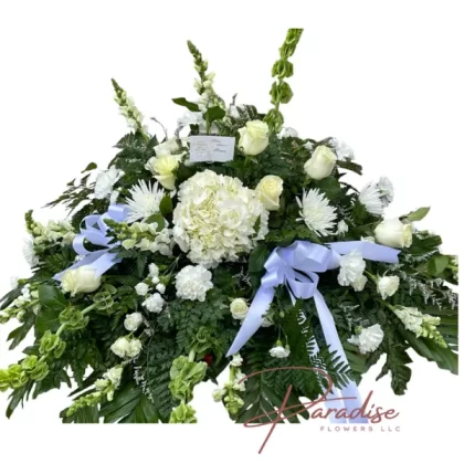 Eternal Peace Casket Spray with white hydrangeas, roses, carnations, spider mums, and greenery symbolizing serene elegance and grace.