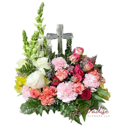 Life Bouquet floral arrangement featuring white snapdragons, roses, carnations, spray roses, astromelias, limonium, and greenery, accompanied by a Crystal Cross keepsake.