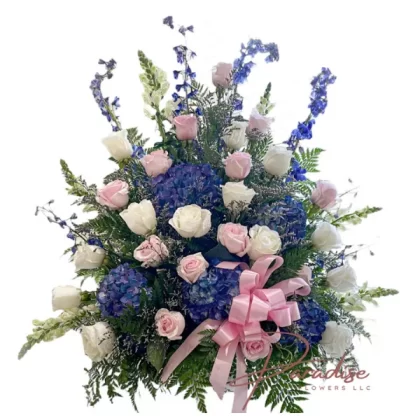 Memorial Elegance floral arrangement featuring white snapdragons, gladiolus, pink and white roses, blue hydrangeas, delphinium, limonium, and greenery.