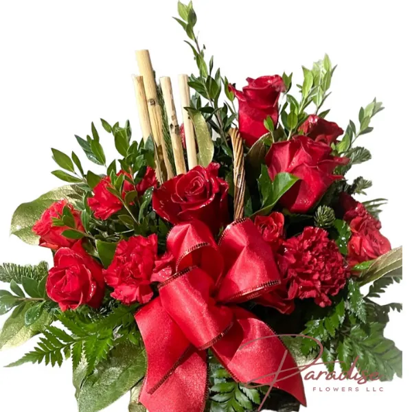 Merry and Bright floral arrangement with red roses, spray roses, carnations, bamboo accents, and lush greenery, creating a festive and elegant holiday display.