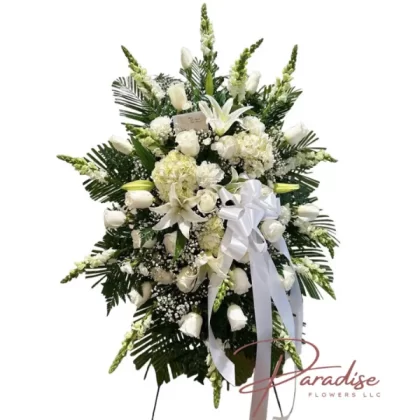 Pure Soul standing spray featuring white roses, snapdragons, carnations, lilies, hydrangeas, baby's breath, and greenery.