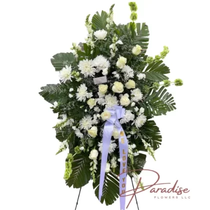 Sentimental Memories Standing Spray with white roses, spray roses, mini carnations, chrysanthemums, snapdragons, and Bells of Ireland, accented by lush greenery.