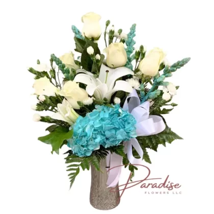 Silver Cross Bouquet featuring white hydrangeas, roses, snapdragons, mini carnations, and lilies in a ceramic vase with a metallic finish and cross cut-out.