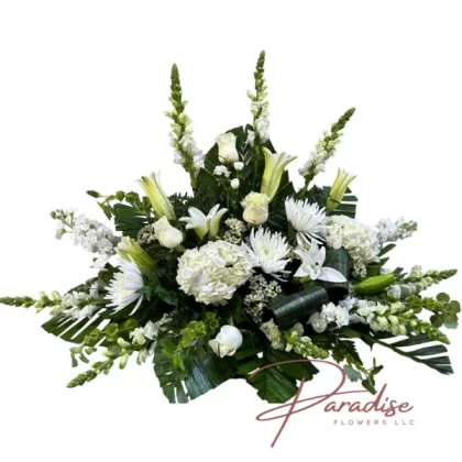 Sweet Reflections floral arrangement featuring white lilies, roses, mini carnations, snapdragons, stocks, hydrangeas, spider mums, waxflower, bells of Ireland, and greenery.