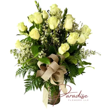 Two dozen white roses in a vase, symbolizing purity, grace, and serenity.