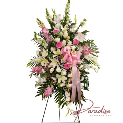 Tranquil Reflections standing spray with pink roses, white snapdragons, pink and white gladiolus, white carnations, lilies, baby's breath, and greenery.