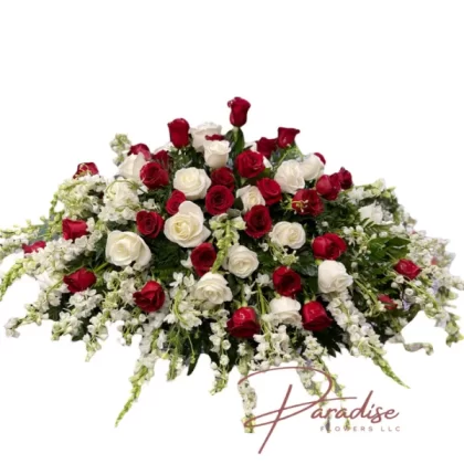 White and Red Harmony Casket Spray featuring white roses, red roses, snapdragons, delphinium, and greenery, symbolizing peace and serenity.