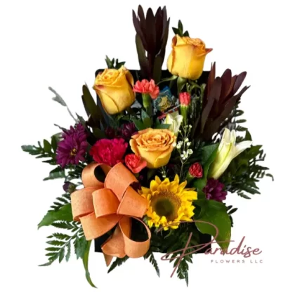 Sunset Serenade Bouquet featuring safari, carnations, roses, sunflowers, lilies, waxflower, and greenery.