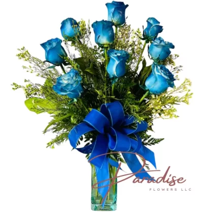 One Dozen Blue Roses Bouquet featuring blue roses, lush greenery, delicate filler flowers, arranged in a blue vase with a matching blue ribbon.