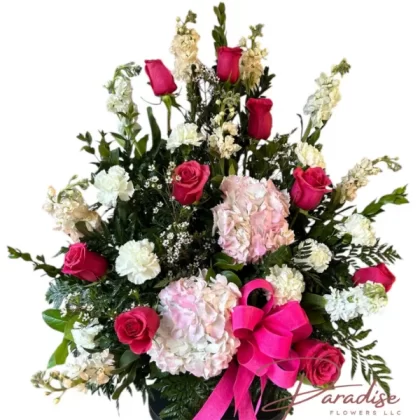 Pink Elegance Bouquet featuring pink roses, white and peach stock, white daisies, white carnations, waxflowers, and lush greenery.