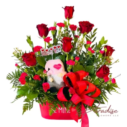 Valentine's Lovers arrangement with red roses, pink carnations, waxflowers, and greenery in a red container, featuring a stuffed animal.