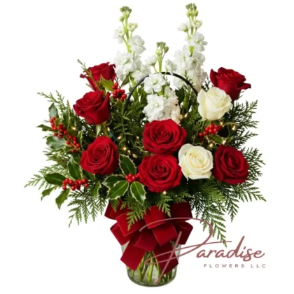 Christmas Rose Glow bouquet with red and white roses, winter greens, fairy lights, and red velvet bow for holiday delivery in Conroe TX