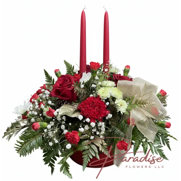 Classic Holiday Candle Centerpiece featuring two red taper candles, red roses, carnations, white blooms, and a gold ribbon for Christmas dinner tables.
