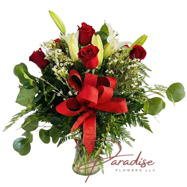 Eternal Kiss floral arrangement featuring 7 red roses, 4 white lilies, and a large red bow in a clear glass vase.