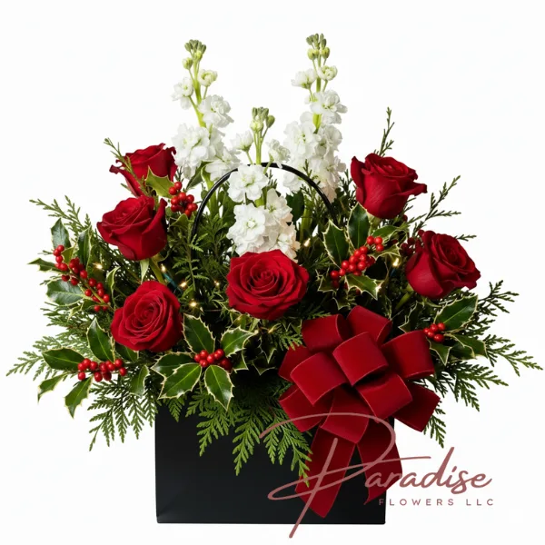 Modern Christmas flower arrangement with red roses, white stock, holly berries, and a red velvet bow in a sleek black box – Holiday gift idea by Paradise Flowers.