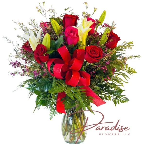 Romantic Harmony bouquet featuring 5 white lilies, 6 red roses, and 6 hot pink roses accented with a large red bow in a clear glass vase.