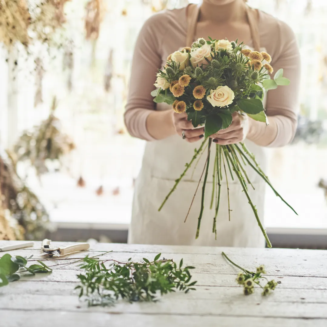 Expert florist at Paradise Flowers in Conroe, TX, meticulously crafting a bespoke luxury bouquet.