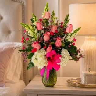 Cheers to Flowers arrangement placed on a luxury bedroom nightstand.